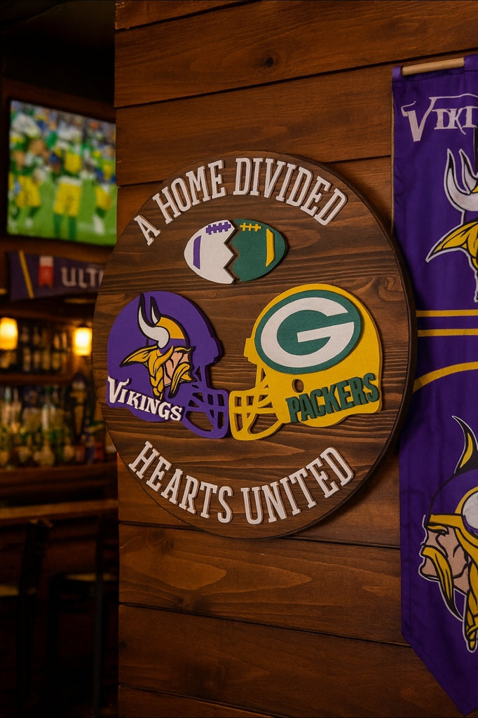 Wooden plaque with Vikings and Packers logos and text 'A Home Divided, Hearts United' on a wooden wall.